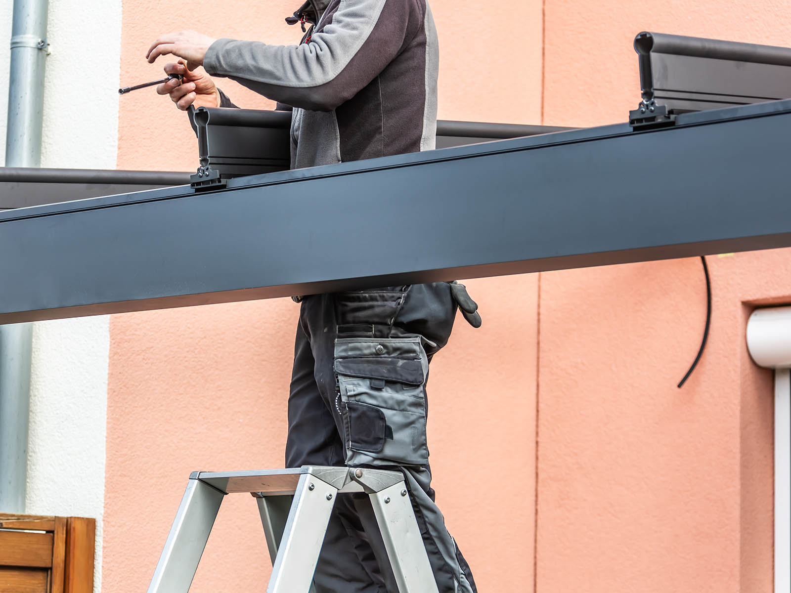 Ein Monteur nutzt Befestigungstechnik um Metallteile zu verbinden