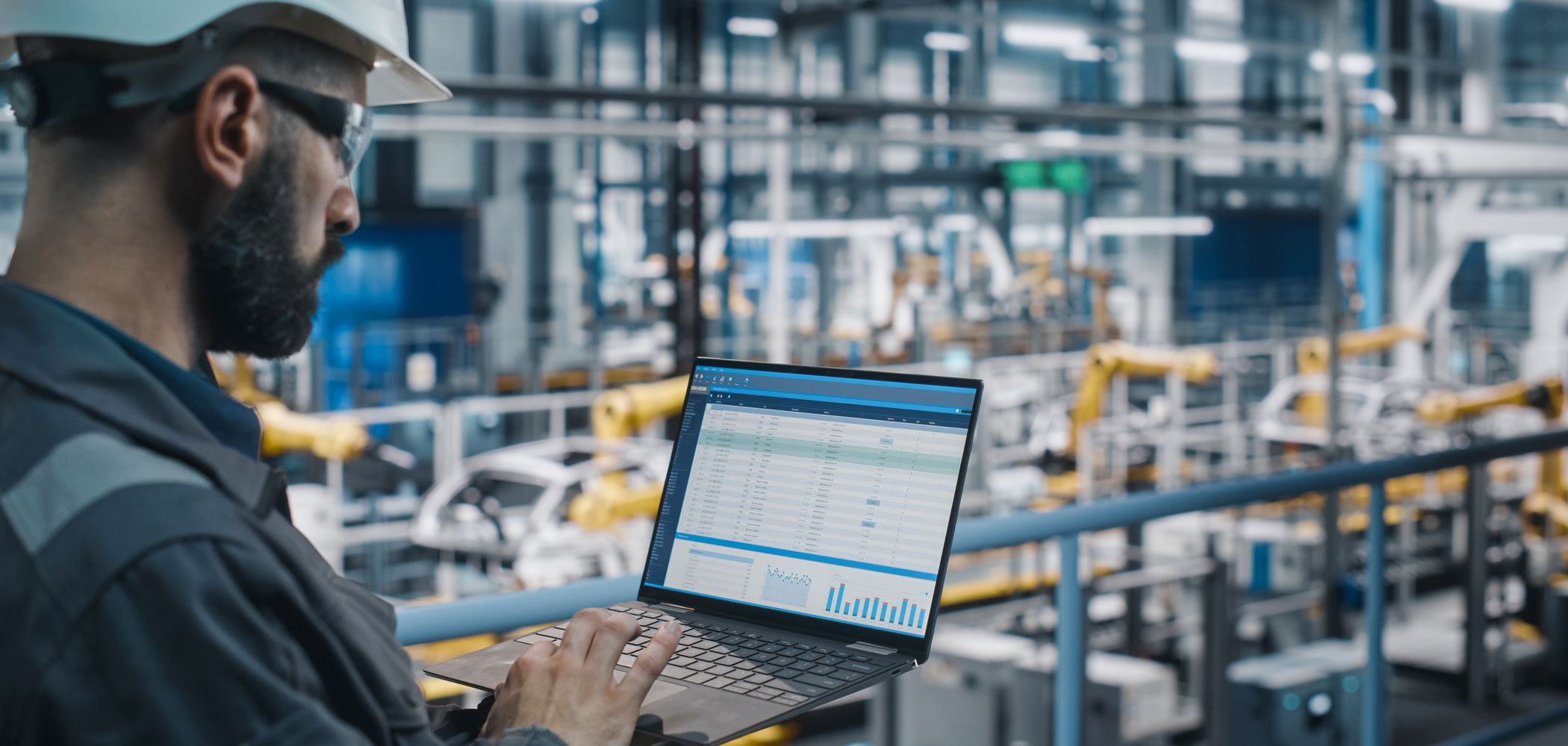 Ein Arbeiter einer Produktion mit einem Laptop